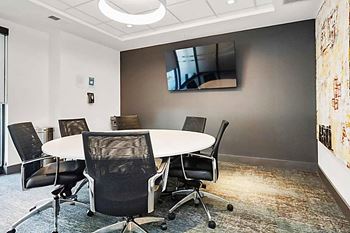 A conference room with a white table and chairs